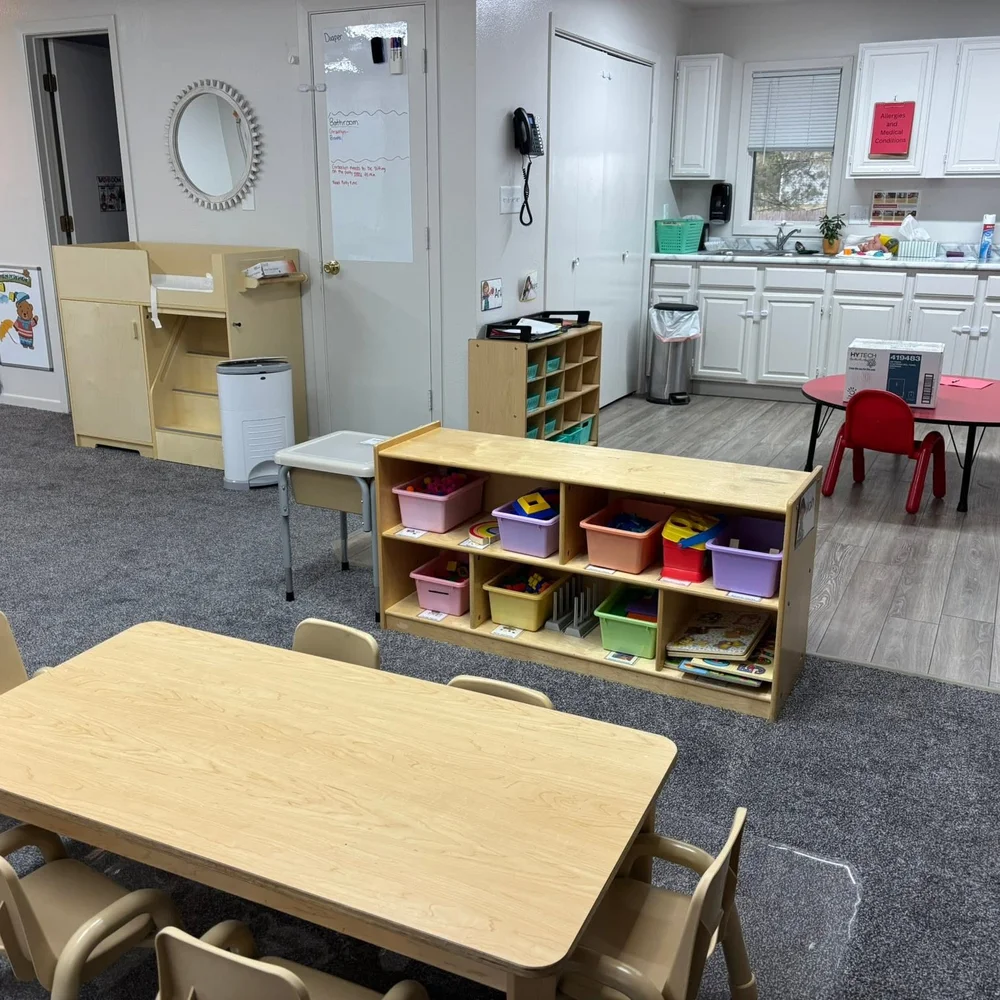 Toddler activity room with sorted manipulative bins, changing station, and a sink area