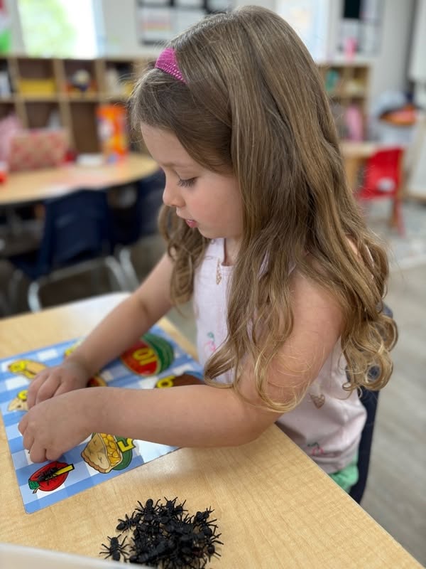 School age girl completing a food matching puzzle at The Nest